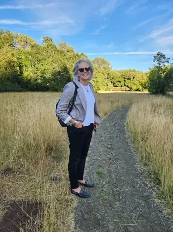 Alix standing on a nature trail smiling